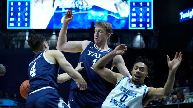 Rams guard Zek Montgomery heads to the floor after trying to drive between Bulldog defenders John Poulakidas and Danny Wolf in the first half.